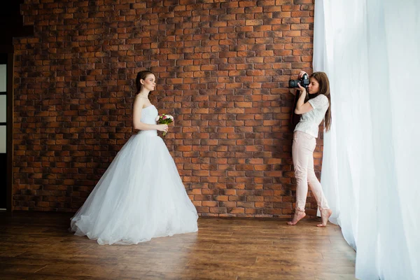 Jeune photographe sexy prend des photos de la mariée dans le studio — Photo