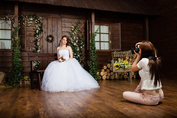 Jonge sexy fotograaf is fotograferen de bruid in de studio — Stockfoto