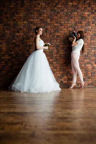 Jeune photographe sexy prend des photos de la mariée dans le studio — Photo