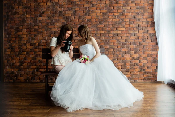 Молодой сексуальный фотограф показывает, что невеста только что сделала фотографии — стоковое фото