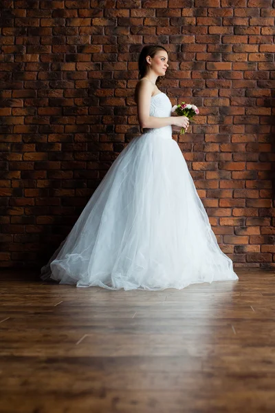 Junge sexy Braut in einem Studio neben der Wand — Stockfoto