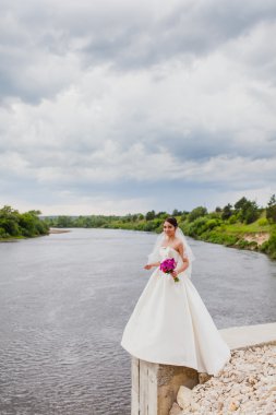 Gelin bulutlar bir arka plan üzerinde nehir kıyısında duruyor