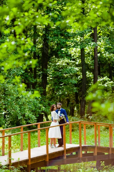 Mariée et marié marchant sur un pont en bois — Photo