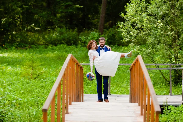 Mariée et marié marchant sur un pont en bois — Photo