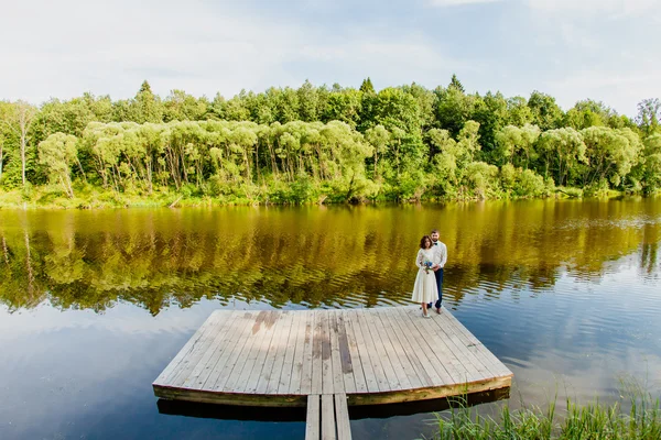 Gelin ve damat gölet yakınındaki ahşap bir iskele üzerinde duran