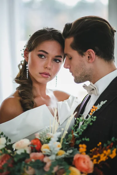 Närbild porträtt av vackra par nygifta med brudbukett — Stockfoto