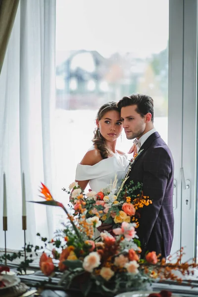 Vackra och eleganta par nygifta poserar med brudbukett — Stockfoto