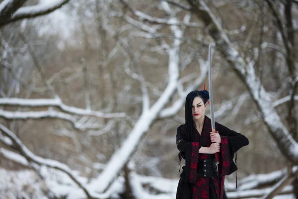 Hermosa joven en un traje de samurai en el río congelado —  Fotos de Stock