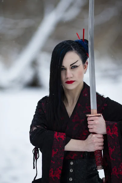 Hermosa joven en un traje de samurai en el río congelado —  Fotos de Stock