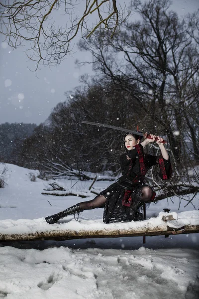 Piękna młoda dziewczyna w garniturze samuraja na zamarzniętej rzece — Zdjęcie stockowe