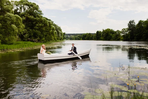 Mariée et marié dans un bateau blanc sur le lac — Photo
