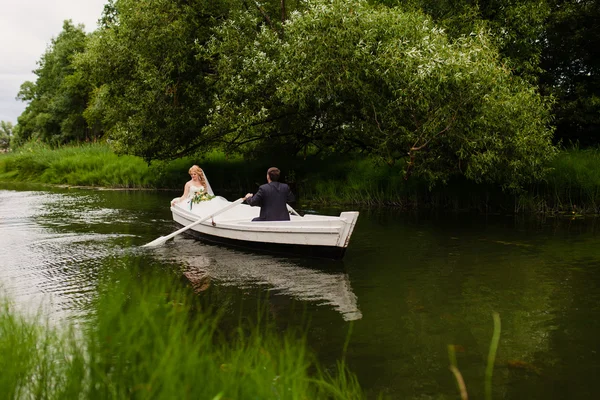 Braut und Bräutigam im weißen Boot auf dem See — Stockfoto