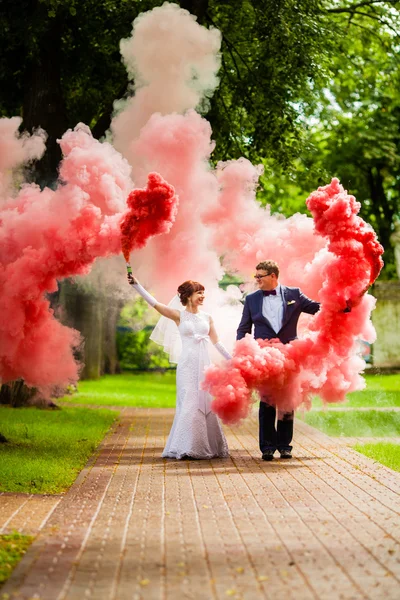 Bruid en bruidegom met een heldere rode rook — Stockfoto