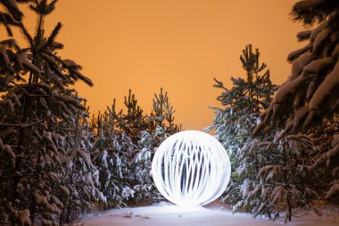 Glowing ball in a pine forest clipart