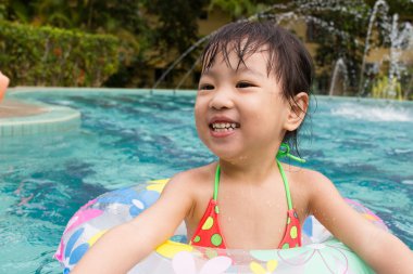 Asyalı küçük Çinli kız yüzme havuzunda oynayan