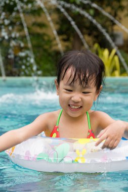 Asyalı küçük Çinli kız yüzme havuzunda oynayan