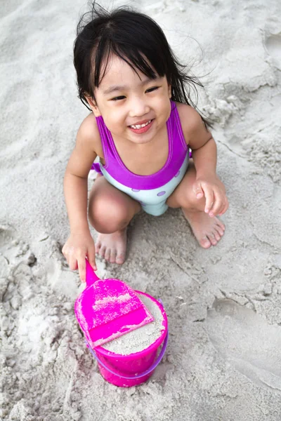 Ázsiai kínai kislány homok, strand játékokat játszani — Stock Fotó