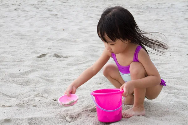 Asyalı küçük Çinli kız kum plaj oyuncakları ile oynarken — Stok fotoğraf