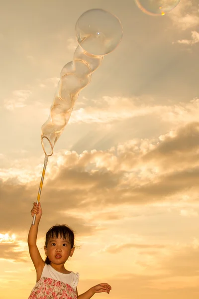 Aziatische Chinees meisje zeepbellen spelen op het strand — Stockfoto