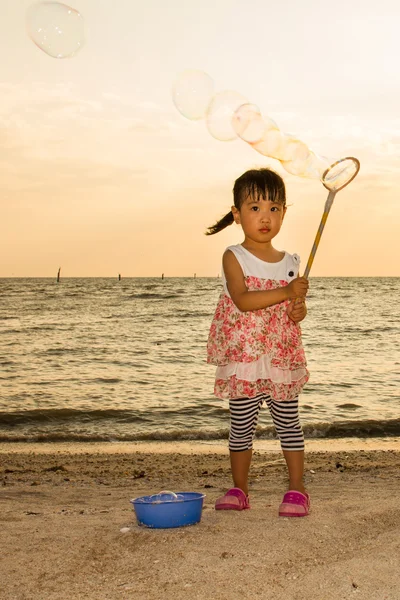 Ázsiai kínai kislány szappanbuborékok játszik a tengerparton — Stock Fotó