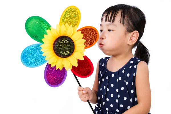 Азиатская маленькая китаянка, дующая разноцветной мельницей — стоковое фото
