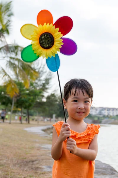 アジアの中国の女の子がカラフルな風車を再生 — ストック写真