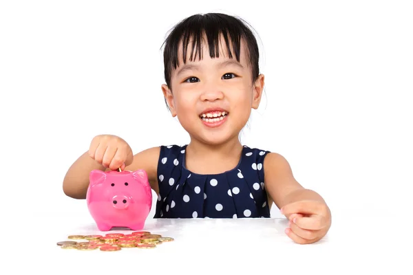 Asiática poco china chica poniendo monedas en piggy bank — Foto de Stock