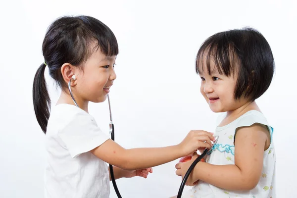 Азиатские маленькие китайские девочки играют в доктора и пациента с St — стоковое фото