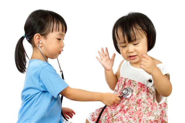Азиатские маленькие китайские девочки играют в доктора и пациента с St — стоковое фото