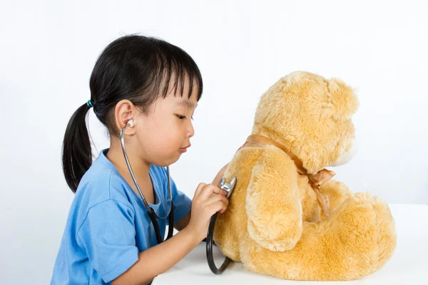 Азіатський китайський дівчинка грає лікар з ведмедиком — стокове фото