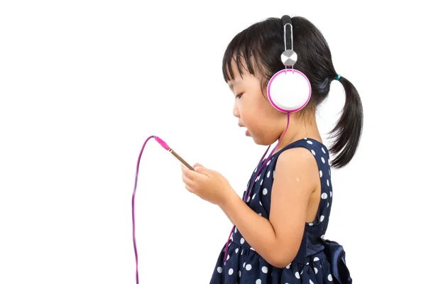 Azjatycki chiński dziewczynka przy użyciu telefonu z zestawem słuchawkowym — Zdjęcie stockowe