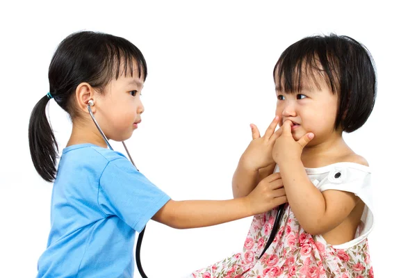 Asian Little Chinese Girls Playing as Doctor and Patient with St Royalty Free Stock Images