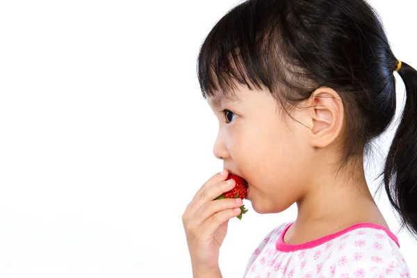 Азиатская маленькая китаянка ест клубнику — стоковое фото