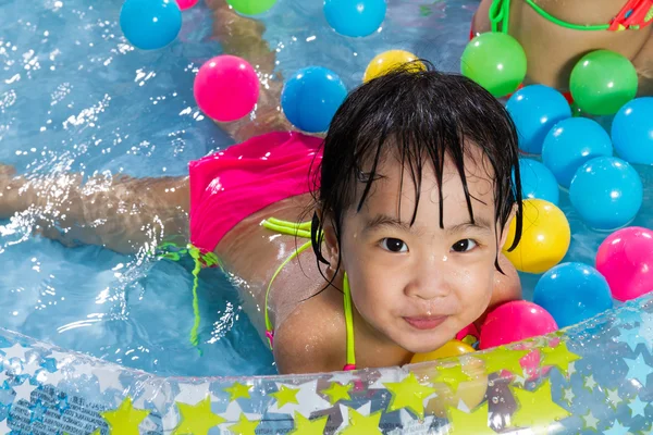 Asiático poco china chica jugando en un inflable goma swimmi — Foto de Stock