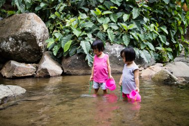 Asian Little Chinese Girls Playing in Creek clipart