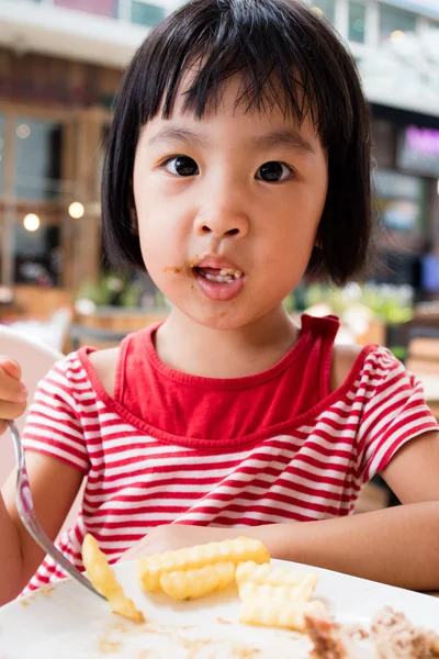 Asiatiska lilla kinesiska flickan äta pommes frites — Stockfoto
