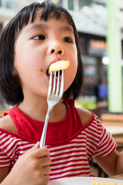 Asiatiska lilla kinesiska flickan äta pommes frites — Stockfoto