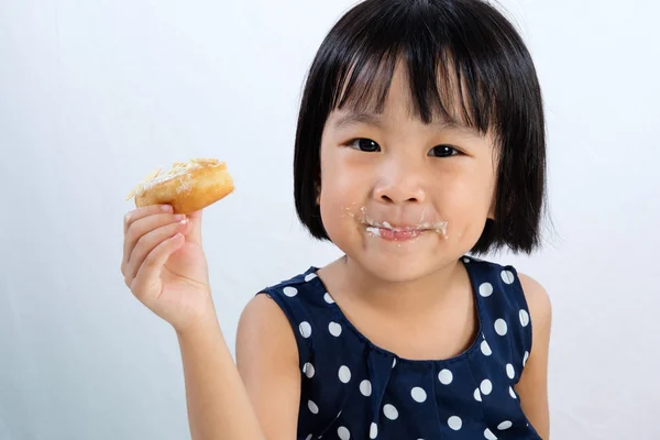 Asiatiska lilla kinesiska flickan äta munkar — Stockfoto