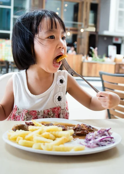 Asiatiska liten kinesisk flicka äter västerländsk mat — Stockfoto