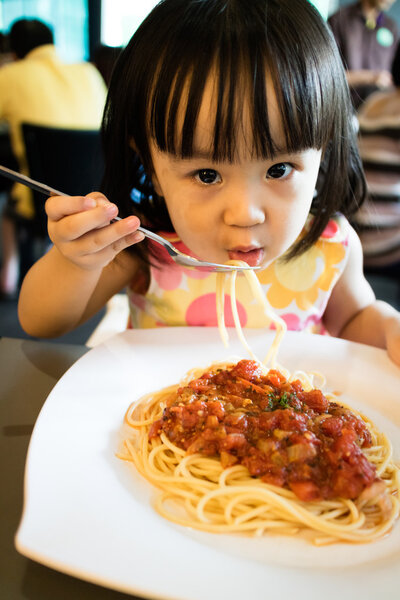 Азиатская маленькая китаянка ест спагетти
