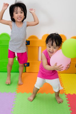Asyalı küçük Çinli kızlar balonlarla oynamayı