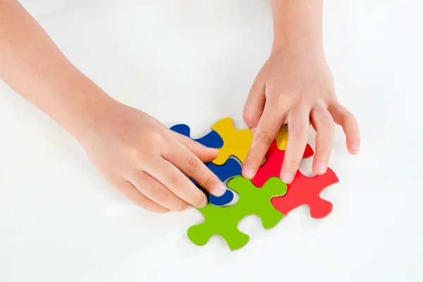 Niño jugando rompecabezas colorido —  Fotos de Stock
