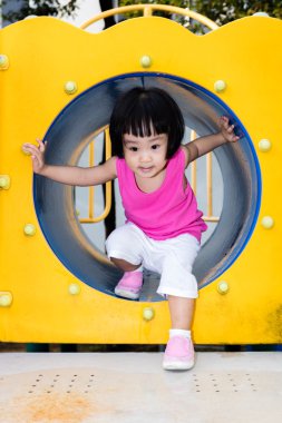 Asyalı küçük Çinli bir tüp içinde oynayan kız