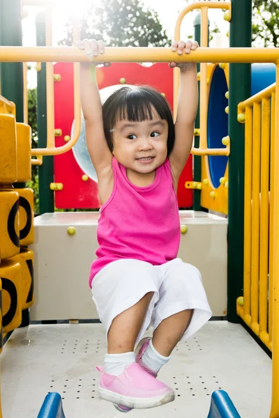 Asiatique petite fille chinoise accroché sur barre de singe horizontale — Photo