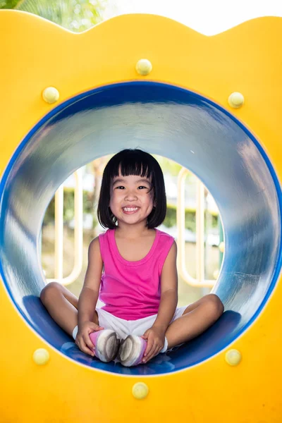 Asiático chinês menina sentado no playground — Fotografia de Stock