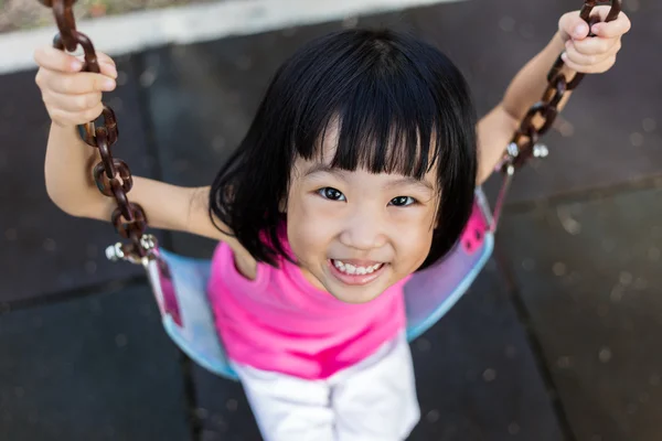 Asiatico cinese bambina su swing in parco giochi — Foto Stock