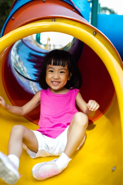 Asiatique chinois petite fille coulissant à aire de jeux — Photo