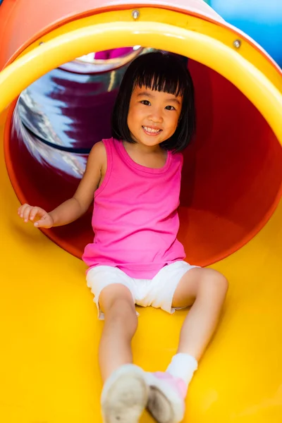 Asiática china niña deslizándose en el patio de recreo — Foto de Stock