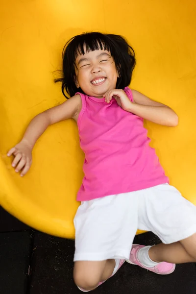 Asian Chinese little girl sliding at playground — Stock Photo, Image