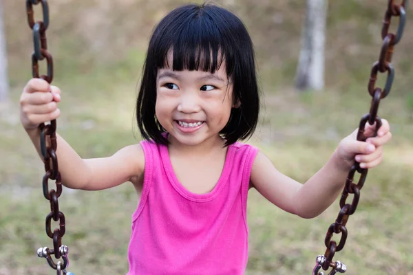 Asiática china niña en swing en patio de recreo — Foto de Stock